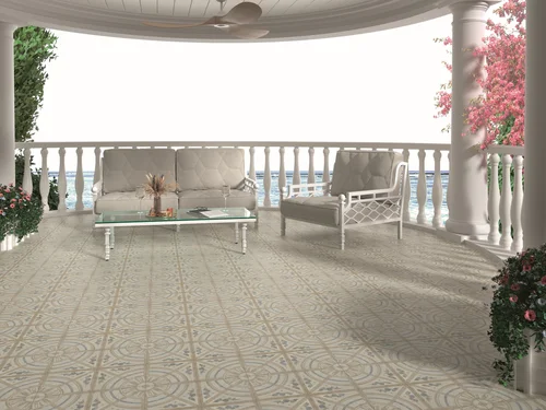 Outdoor verandah overlooking the water, styled with white seating and greenery, featuring Mikron Medalyon patterned floor tiles in soft cream and blue mosaic tones.