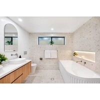Light neutral bathroom with a curved bath, timber vanity and tiled shower